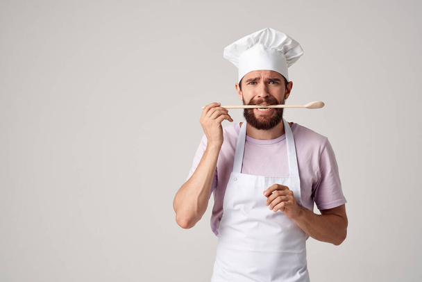 chef profesional masculino en delantal sosteniendo una cuchara servicio de cocina de alimentos - Foto, Imagen