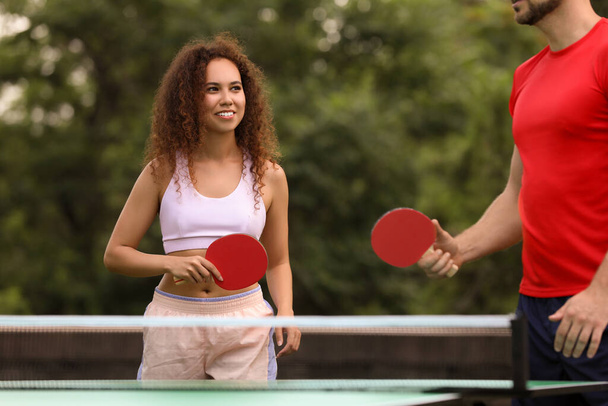Friends playing ping pong outdoors on summer day - Foto, imagen