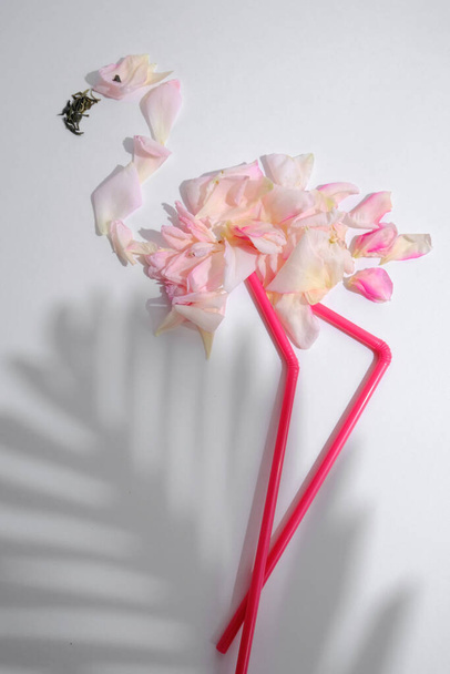 Pink flamingo made of petals and straws on a white background. - Fotografie, Obrázek