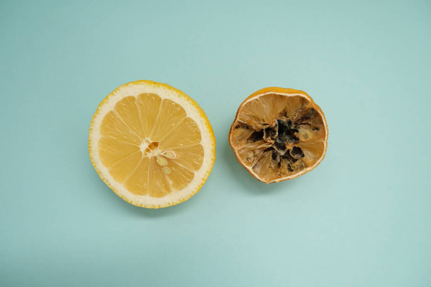 Halves of fresh and rotten lemon on a blue background. - Foto, immagini