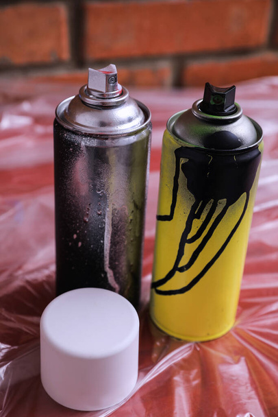 Used cans of spray paints on table. Graffiti supplies - Photo, image