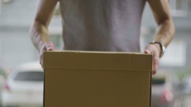 Samiec kuriera daje kartonowe pudełko zbliżenie - Materiał filmowy, wideo