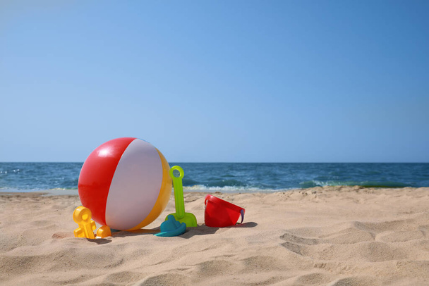 Many different sand toys and beach ball near sea, space for text - Фото, зображення
