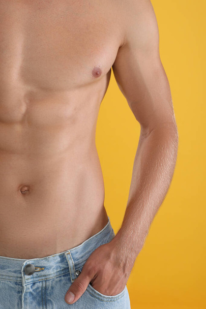 Shirtless man with slim body on yellow background, closeup - 写真・画像