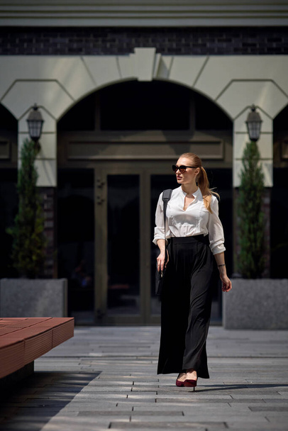 beautiful woman in sunglasses in the street - Fotografie, Obrázek