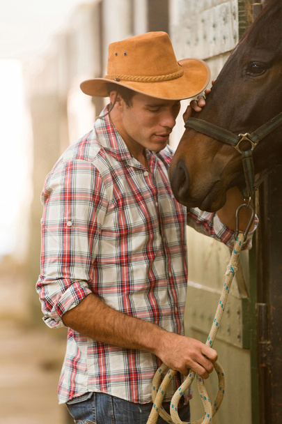 cowboy whispering to a horse - Фото, изображение