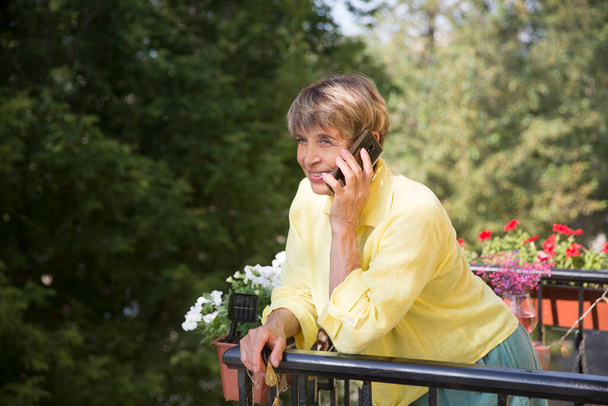 portrait of mature woman talking on mobile phone  - Фото, изображение