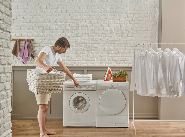 Mann reinigt Waschmaschine von oben, Waschküche. - Foto, Bild