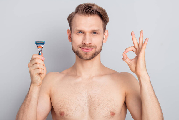 Photo of cheerful confident guy no clothes smiling showing okey shaving cheekbones cheeks isolated grey color background - Foto, imagen