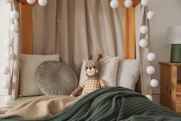 Toy deer on bed in child's room - Foto, Imagen