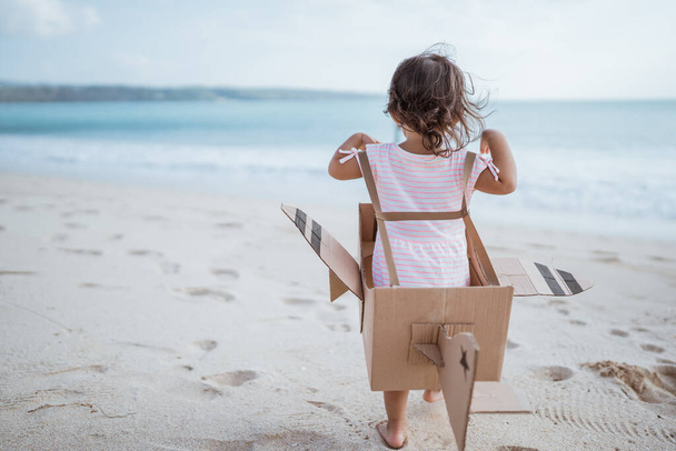 gyerek fut a strandon játszani játék repülőgép készült karton - Fotó, kép