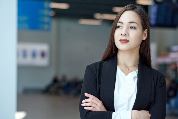 Smiling asian business woman in modern office or meeting room. crossed arms - Foto, Imagen