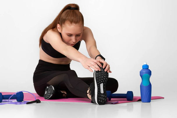 Strong sporty girl in black sportswear working out - Фото, изображение
