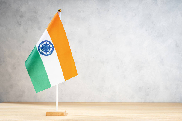 Bandera de mesa de la India en pared con textura blanca. Copiar espacio para texto, diseños o dibujos - Foto, imagen