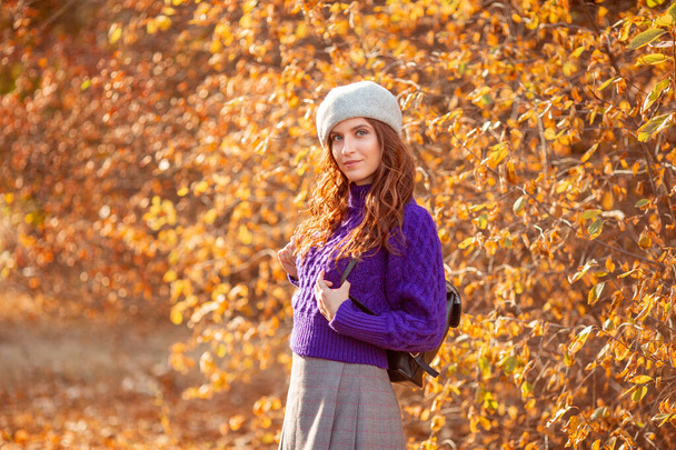 młoda kobieta w jesiennym parku w fioletowym swetrze - Zdjęcie, obraz
