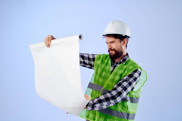 male builder with documents and drawings blueprints isolated background - Foto, Bild
