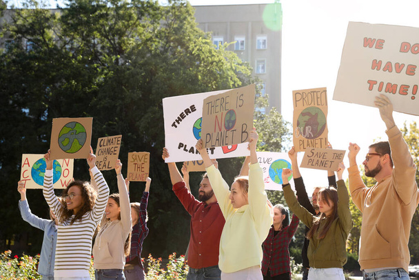 Group of people with posters protesting against climate change outdoors - Foto, imagen