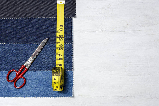 Handicraft, clothing repair. Ripped blue jeans sewing accessories from above. Flat lay - Fotó, kép