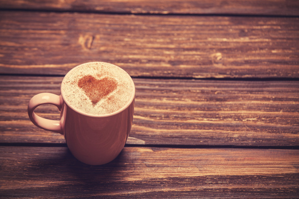 Tasse Kaffee mit Herzform auf Holztisch. - Foto, Bild