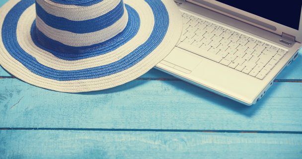 Ordinateur portable et chapeau sur table en bois bleu
. - Photo, image