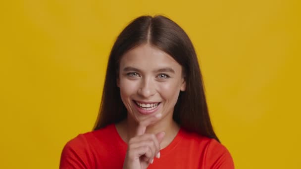 Nő mosolygós és Gesturing Ujj szájon át sárga háttér - Felvétel, videó