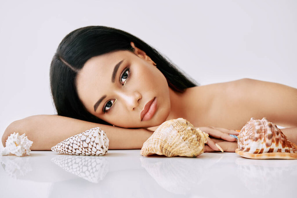 Beautiful african american woman with different seashells on white background - Foto, Imagem