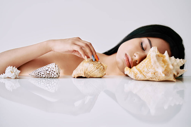 Fashion portrait of beautiful african american woman closed eyes with different seashells - Foto, afbeelding