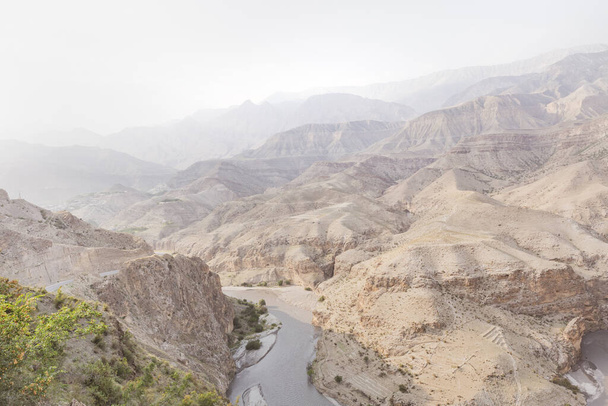 Layers of rocky mountains and hills in haze, bend of a river in a canyon. - Foto, Bild