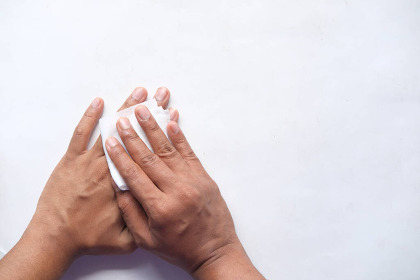  άνθρωπος απολυμαίνει τα χέρια του με ένα υγρό σκούπισμα σε λευκό φόντο  - Φωτογραφία, εικόνα