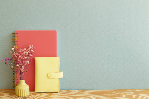 Cuaderno rosa y amarillo con flores secas sobre escritorio de madera. fondo de pared de menta. espacio de copia - Foto, Imagen