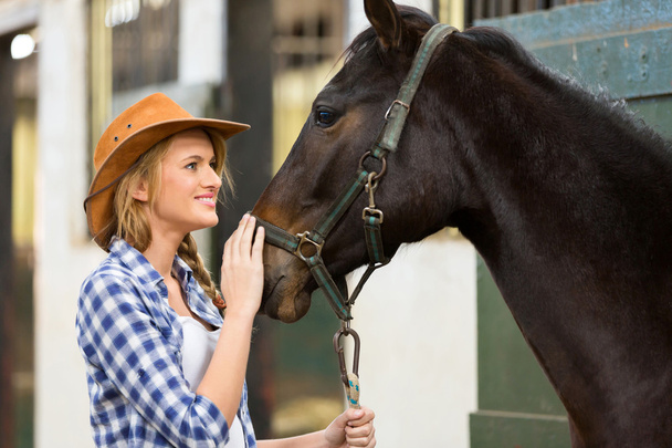 cowgirl and horse inside stable - Фото, зображення