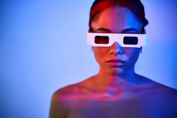 Pretty african american woman wearing 3D glasses in neon light - Φωτογραφία, εικόνα