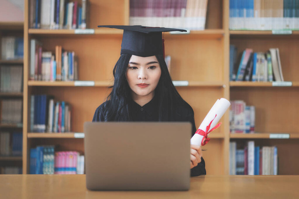 Fiatal ázsiai női egyetemi diplomás diplomás ünnepli virtuális diploma egy videohívás - Fotó, kép