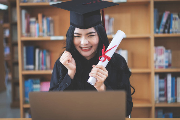 Joven mujer asiática graduada universitaria con grado celebra la graduación virtual a través de una videollamada - Foto, Imagen