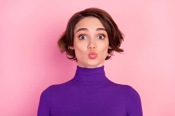 Foto von flirty Brünette Millennial Dame Schlag Kuss tragen violetten Pullover isoliert auf rosa Hintergrund - Foto, Bild
