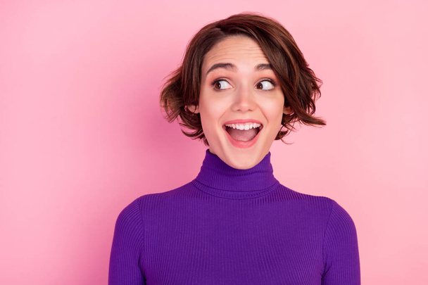 Photo of funny brunette young lady look empty space wear violet sweater isolated on pink color background - Foto, immagini