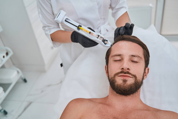 Man being treated for hair loss in a beauty clinic - Photo, Image