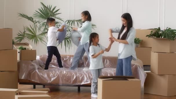 Японская семья празднует переезд дома весело среди коробок в помещении - Кадры, видео