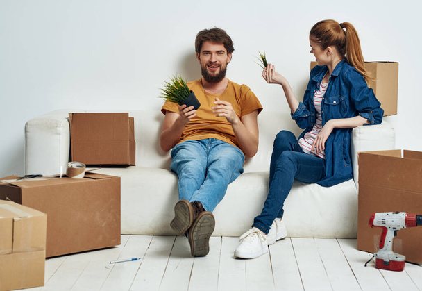 giovane coppia seduta sul divano scatole con le cose rinnovare housewarming in movimento - Foto, immagini