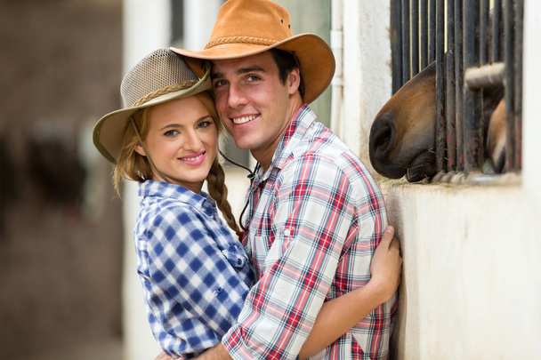 western couple hugging in stables - Foto, afbeelding