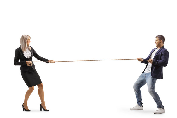 Full length profile shot of a businesswoman and a casual man pulling a rope isolated on white background - Foto, Bild