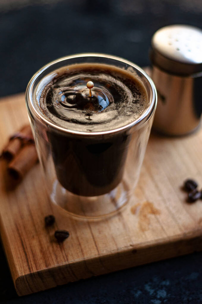 The double espresso coffee mug with cinnamon sticks and coffee beans on a wooden board - Фото, зображення