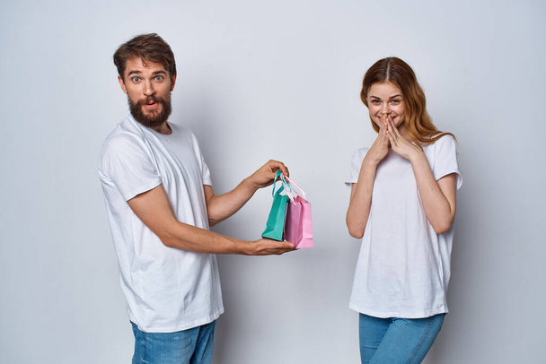 cheerful man and woman with gifts in hands shopping lifestyle - Zdjęcie, obraz