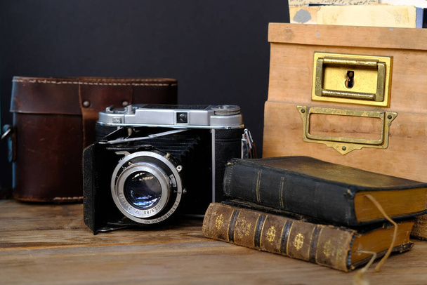 old family photos 50s, 40s, retro camera, books on wooden table, concept of genealogy, memory of ancestors, family tree, childhood memories, home archive - Fotografie, Obrázek