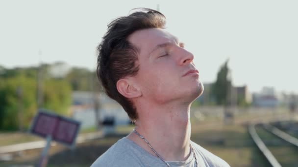 Portret jonge serieuze man die staat met zijn ogen dicht en inhaleert diep - Video