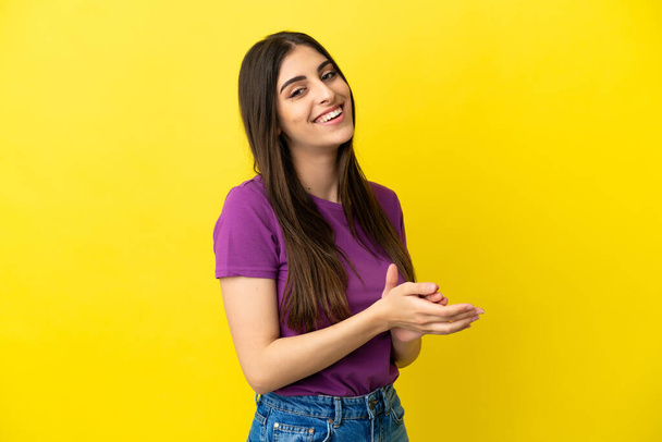Young caucasian woman isolated on yellow background applauding - Fotó, kép