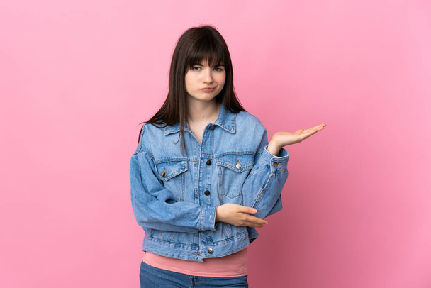 Young Ukrainian woman isolated on pink background having doubts - Photo, Image