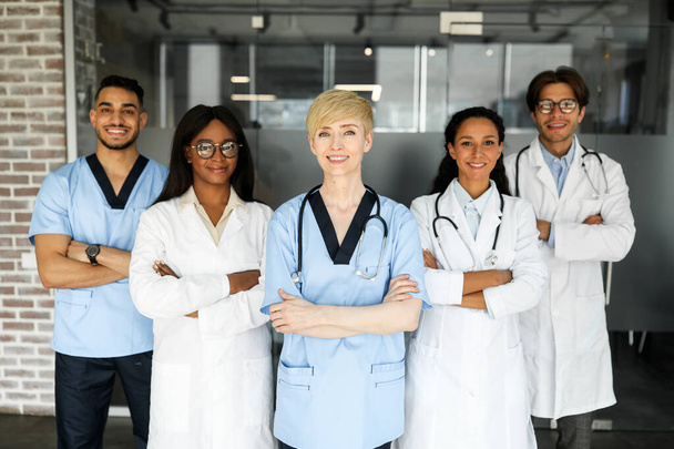 Дружеская команда многорасовых врачей позирует в больнице - Фото, изображение