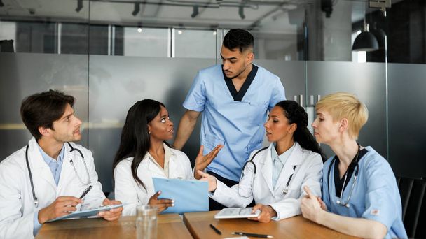 Skoncentrowana wielorasowa grupa lekarzy biorących udział w konsultacjach - Zdjęcie, obraz