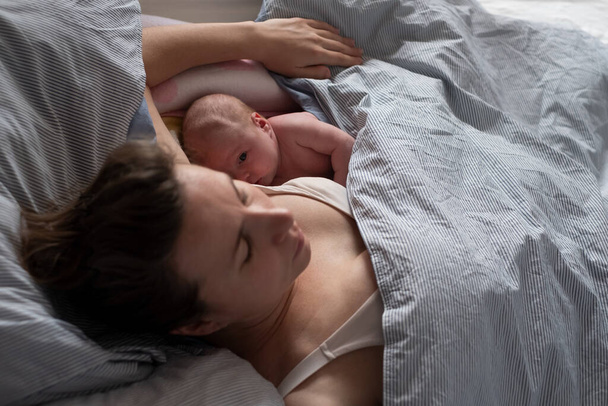 Bébé couchant avec sa mère au lit. - Photo, image